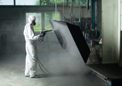 man wearing a white suit holding a paint sprayer