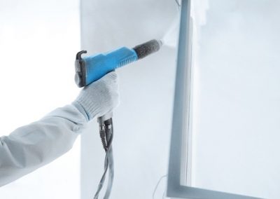 hand wearing white glove holding a paint sprayer